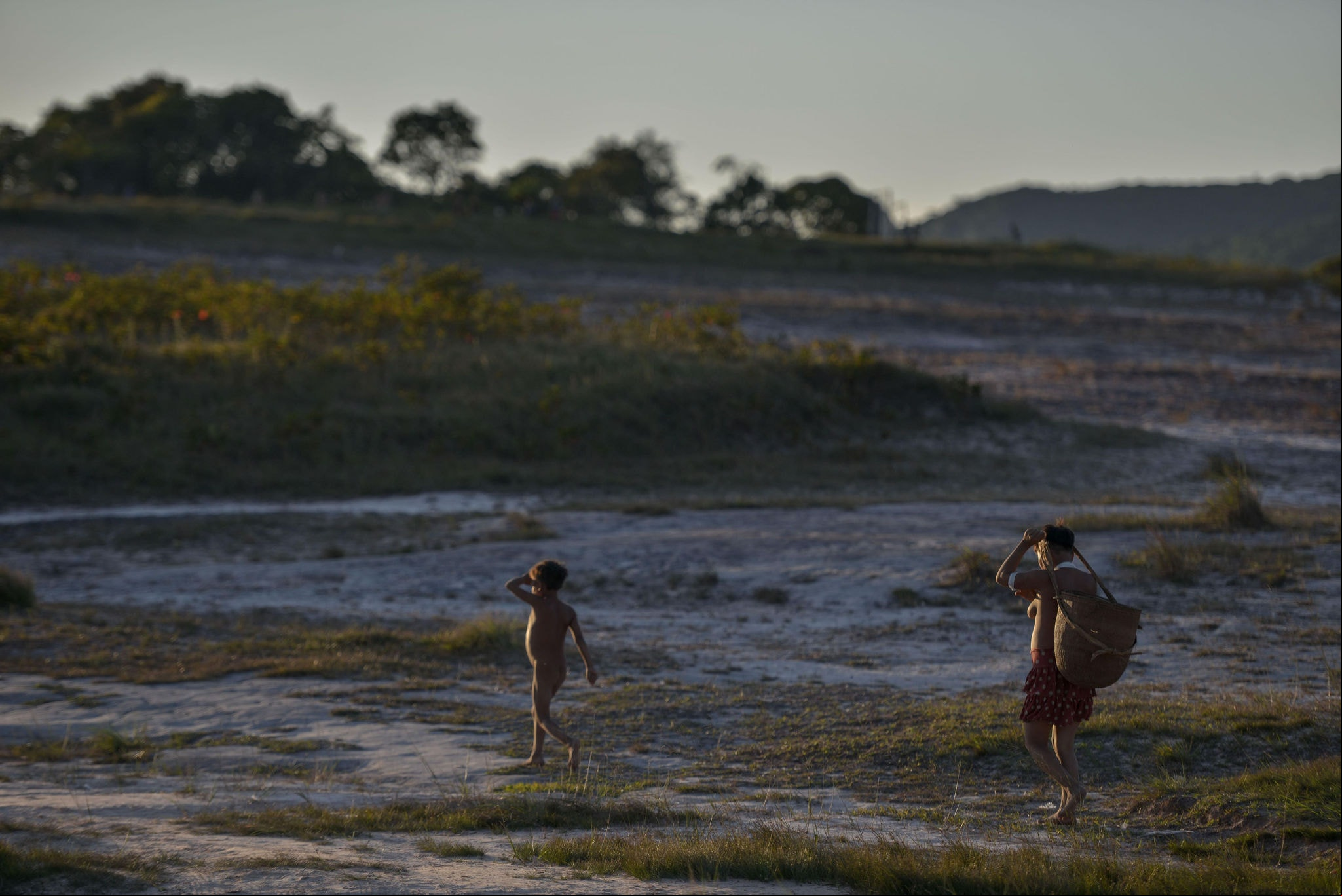 Yanomami, acompanhada de criança, carrega alimentos para casa. Luta da mulher indígena é por sua cultura, seu território e seu povo. Foto: Fred Magno / O TEMPO